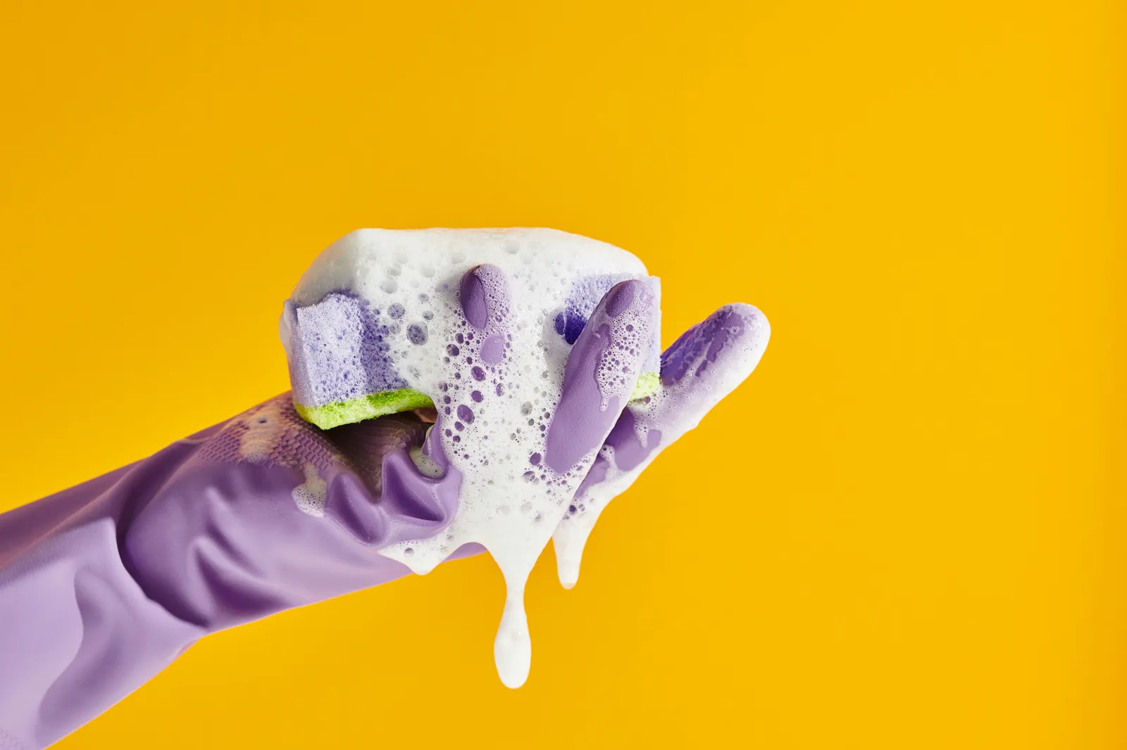 Gloved hand methodically wiping a surface with a cloth