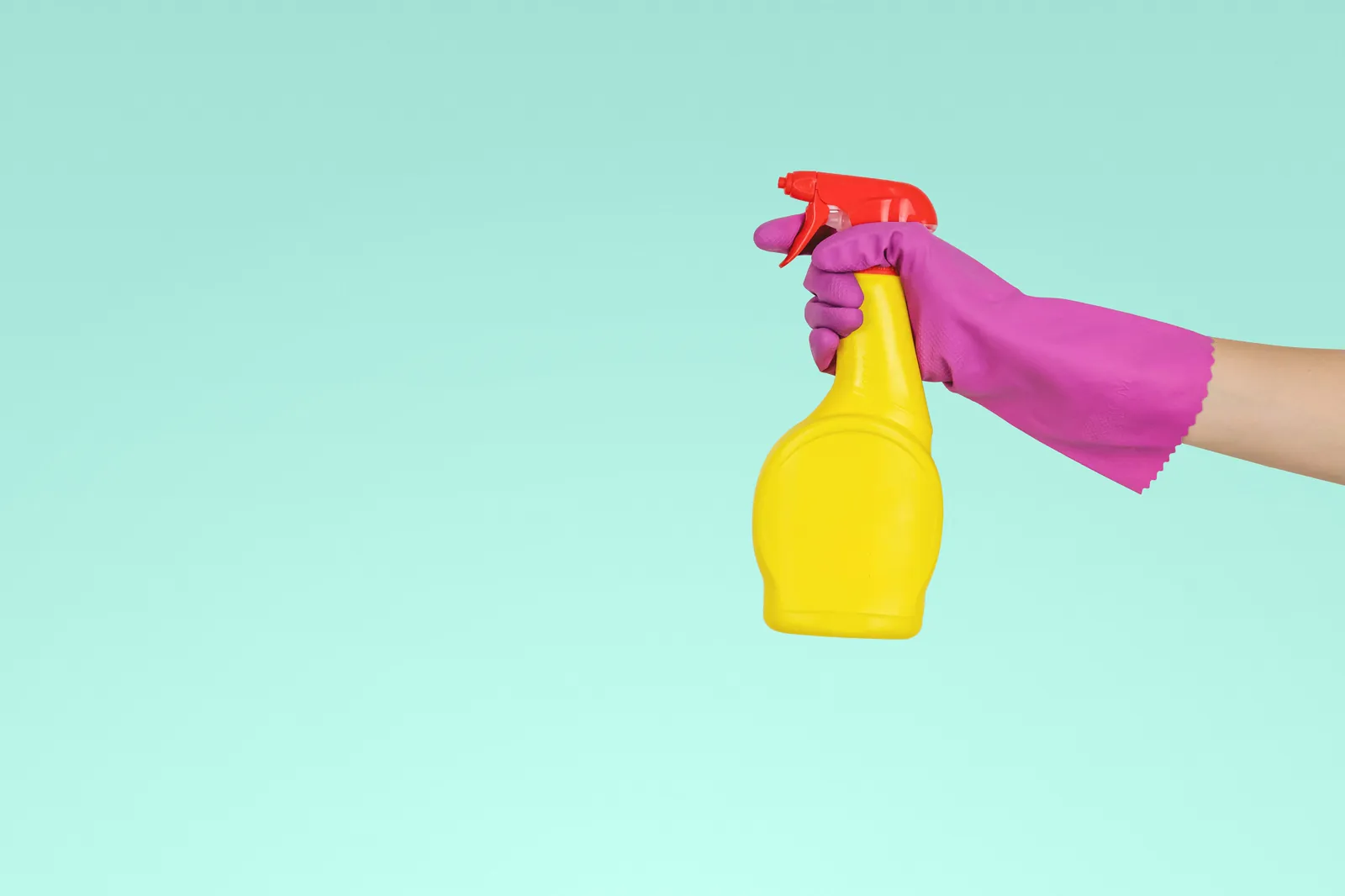 Experienced cleaner using a spray bottle and gloves